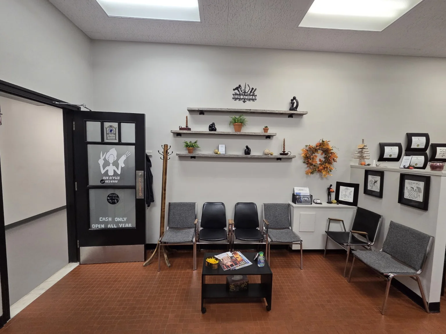 A wide view across the SUB Styles waiting area, with salon chairs and a low table.